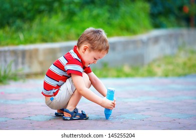 Small Kid Painting The Ground With Chalk