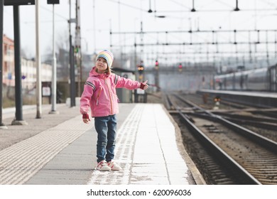 small kid standing alone on train station. cute girl in preschool age waiting for railway arrival. alone child standing and stacking hand out on platform.  - Shutterstock ID 620096036