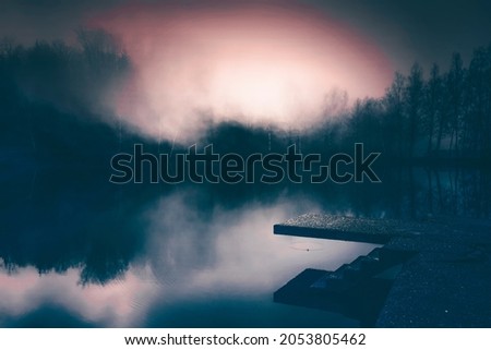 Small lake in enchanted forest in magic, mysterious fog at night. Halloween background