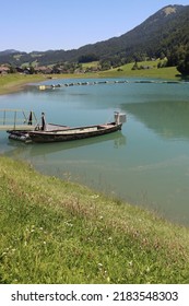 Small Lake Of Hydroelectric Power Plant. Green Energy Is Produced Just There With A Hydroelectric Turbine And Water From This Idyllic Lake In Front. Electricity Without Co2 Emmissions.