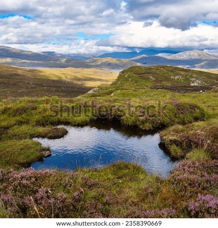 Small lake at the top of the green mountains near Ullapol, Scotland, UK.
