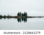 Small land peninsula or breakwater into Lake Superior, with a calm reflection on the water, in Grand Marais, Minnesota