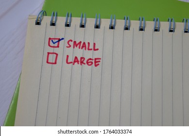 Small and Larger write on a book. Supported by an additional services isolated wooden table.