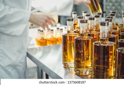 Small liquor production based on maple syrup. Multitude of pure alcohol bottles
 not labeled. Bottles placed in a row. - Powered by Shutterstock