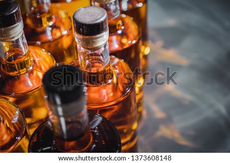 Small liquor production based on maple syrup. Multitude of pure alcohol bottles
 not labeled. Bottles placed in a row.