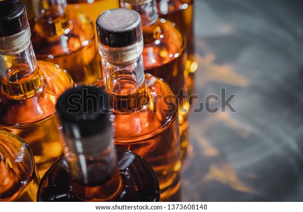 Small\
liquor production based on maple syrup. Multitude of pure alcohol\
bottles\
 not labeled. Bottles placed in a\
row.