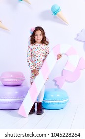 Small little girl beautiful lady curly hair child wear funny clothes dress socks boots cute face smile sweets baby shower party bar game room birthday hold big candy lollipop macaroons toy play fun. - Shutterstock ID 1045228264