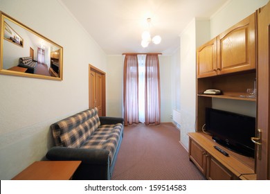 Small Living Room With A Blue Checkered Sofa, Wall Cabinet And TV