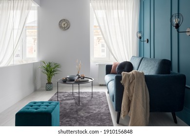 Small Living Room With Blue Couch, Ottoman And Simple Coffee Table And With Glass Wall And Windows With White Curtains