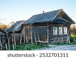 A small log house of the 18-19th century, The cowshed and barn are attached. Slate roof of the mid-20th century. The dwelling of a poor peasant. Central Russia, Tver Region