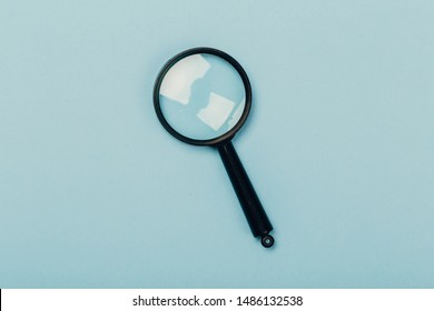 Small magnifying glass on pastel blue background, search symbol - Shutterstock ID 1486132538