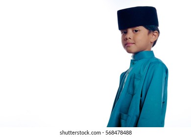 A Small Malay Boy Is Smiling, Wearing A Baju Melayu And Songkok, A Traditional Malay Costume Isolated With White Background