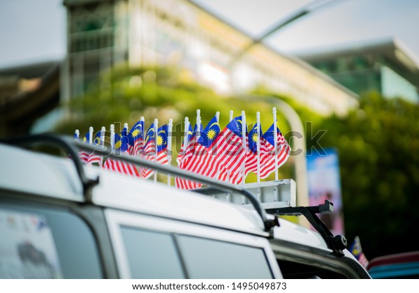 Small Malaysian flags attached to the\
car roof during Independence Day or \