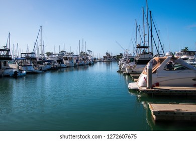 Small marina with deep blue water and many sail and power boats docked in slips - Shutterstock ID 1272607675
