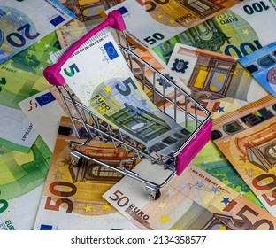 small market handcart with a euro banknote on background of euro cash banknotes close up, supermarket trolley with money    