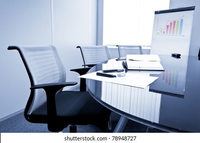 Small Meeting Room With Flip Chart, Chairs And Glass Table.