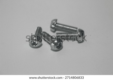 Small metal hex socket screws isolated on white background. Stainless steel machine screws for mechanical, industrial, and bicycle components, photographed in a clean studio setup.