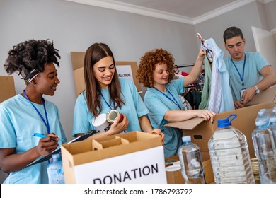 Small mixed race group of people working in charitable foundation. Generous people helping to poor people. Young people working at charitable foundation, packing donation box