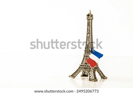 A small model of the Eiffel Tower with a red and white flag on top