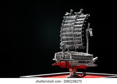 A Small Model Of Famous Ancient Korean Ironclad War Ship. Korean Turtle Ship On A Black Background. Black And White And Red.