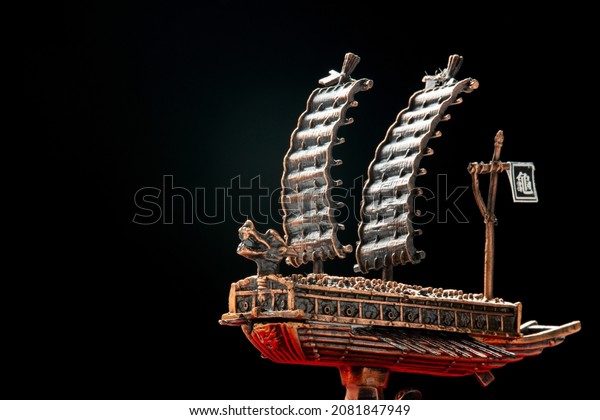 A small model of\
famous ancient Korean ironclad war ship. Korean turtle ship on a\
black background.