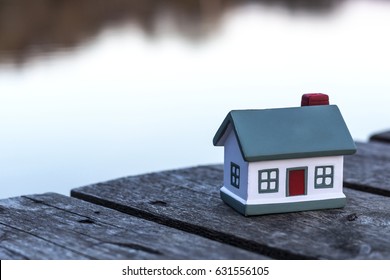 Small model of house on the background of a river. Focus on house.