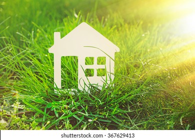 Small Model Of House Over Green Grass Background