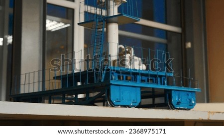Small model of industrial tower. Stock footage. Metal model of industrial tower with platform. Turret with ladder and platform on wheels for industrial project
