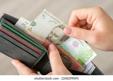 Small money in the wallet, paying for goods concept. Woman dealing with finances, using ukrainian hryvnias while shopping - Shutterstock ID 2240299095