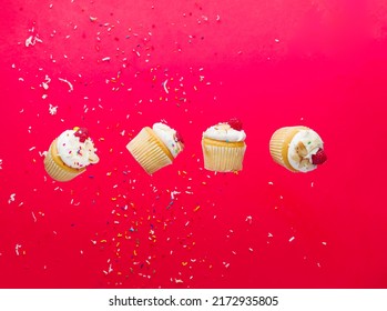 Small Mouth-watering Muffins On A Bright Pink Background With Grains Of Sugar In A Frozen Flight. Banner, Advertisement, Invitation For Birthday, Holiday. There Are No People In The Photo.