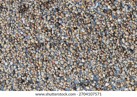 Small multicolor pebbles background, natural gravel stone texture with tiny rounded rocks in assorted colors.
