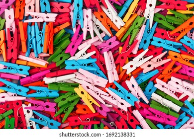 Small multi-colored clothespins as a full-screen texture and background. Decorative clothespins for creativity.
