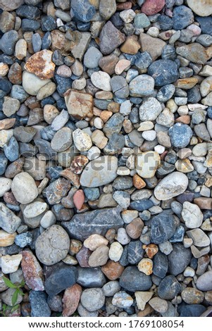 small multi-colored pebbles texture background. colorful stones. vertical photo.