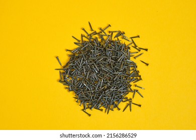 small nails for shoes and furniture on a yellow background close-up