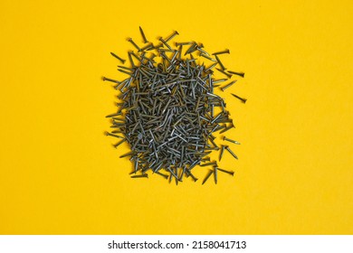 small nails for shoes and furniture on a yellow background close-up