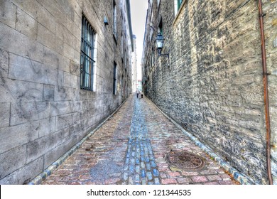 Small narrow street in Old Montreal, and in the background a man walking with his dog, HDR image - Powered by Shutterstock