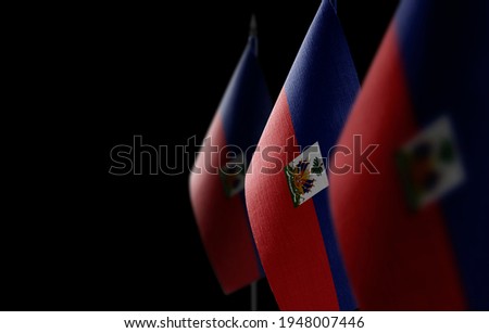 Small national flags of the Haiti on a black background