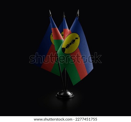Small national flags of the New Caledonia on a black background.