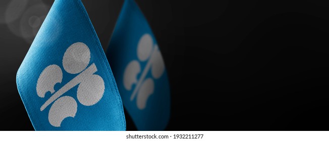 Small national flags of the Organization of the Petroleum Exporting Countries on a dark background