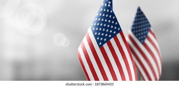 Small national flags of the United States on a light blurry background - Shutterstock ID 1873869433