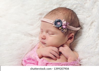 Small Newborn Cute Baby, Infant Girl Sleeping In A Basket In A Flower Dressing On A Rug In A Hat With A Toy, Tenderness Love Care, Angel Smile, Pink-blue Color In A Flower Dressing Bunny