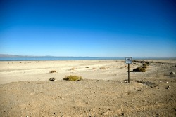 A Small No Trespassing Sign Sits Hundreds Of Yards From The Receding Shoreline Of The Salton Sea In California.