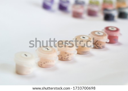 Small numbered jars of paint. Close-up