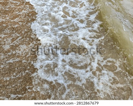Small Ocean Waves Reaching Sandy Beach