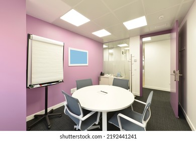 Small Office Cubicle With A Round Boardroom Table With Matching Chairs And A Presentation Lectern