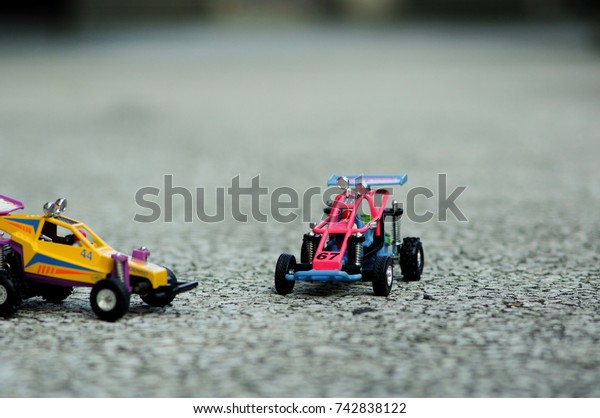 A small offroad toy car for 1 person is on the\
cement floor.