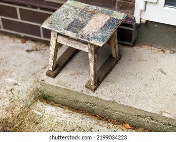 A Small Old Chair Placed Outside A Hose Next To The Door