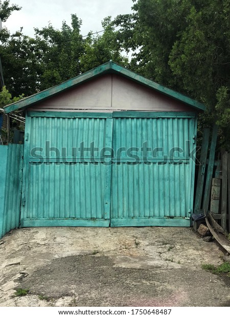 small old garage gate made of wooden doso bright\
turquoise color