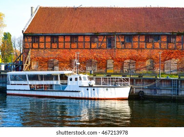 Small old passenger ship was docked next to vintage building. Lithuania.