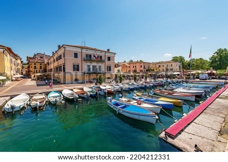 Small old port of the village of Bardolino with many boats moored. Tourist resort on the coast of Lake Garda (Lago di Garda). Verona province, Veneto, Italy, southern Europe.
